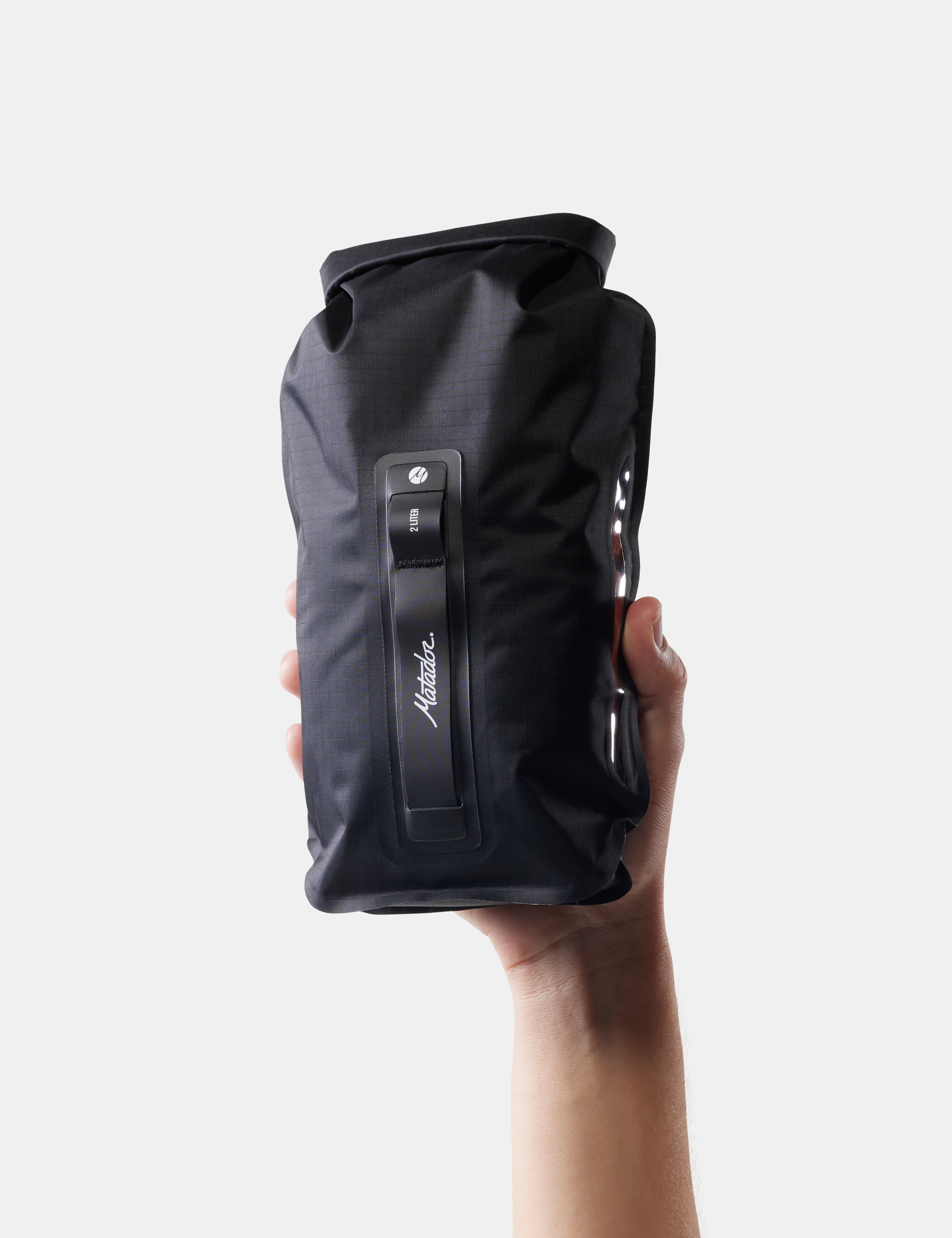Black dry bag held by a hand on a white background