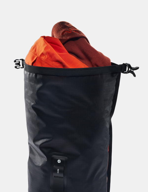 Black bag with orange and brown items inside on a white background