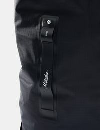 Close-up of a black strap with a brand logo on a dark background