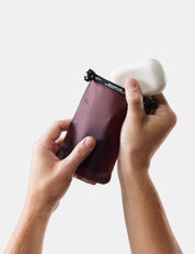 hands putting soap bar into garnet case