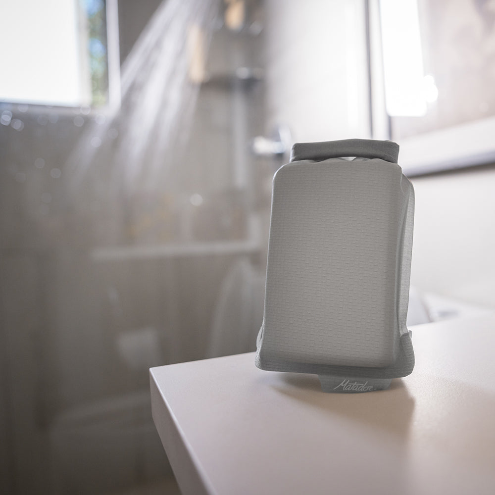 what soap bar case sitting on bathroom counter with shower running in the background