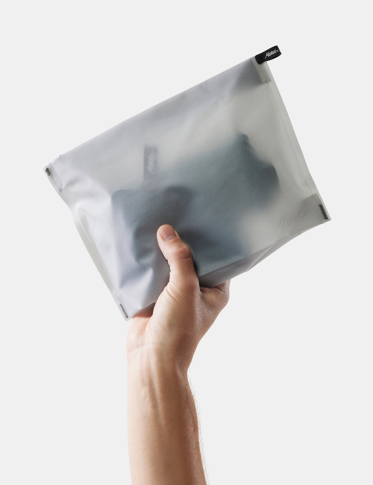 hand holding white toiletry case on white background