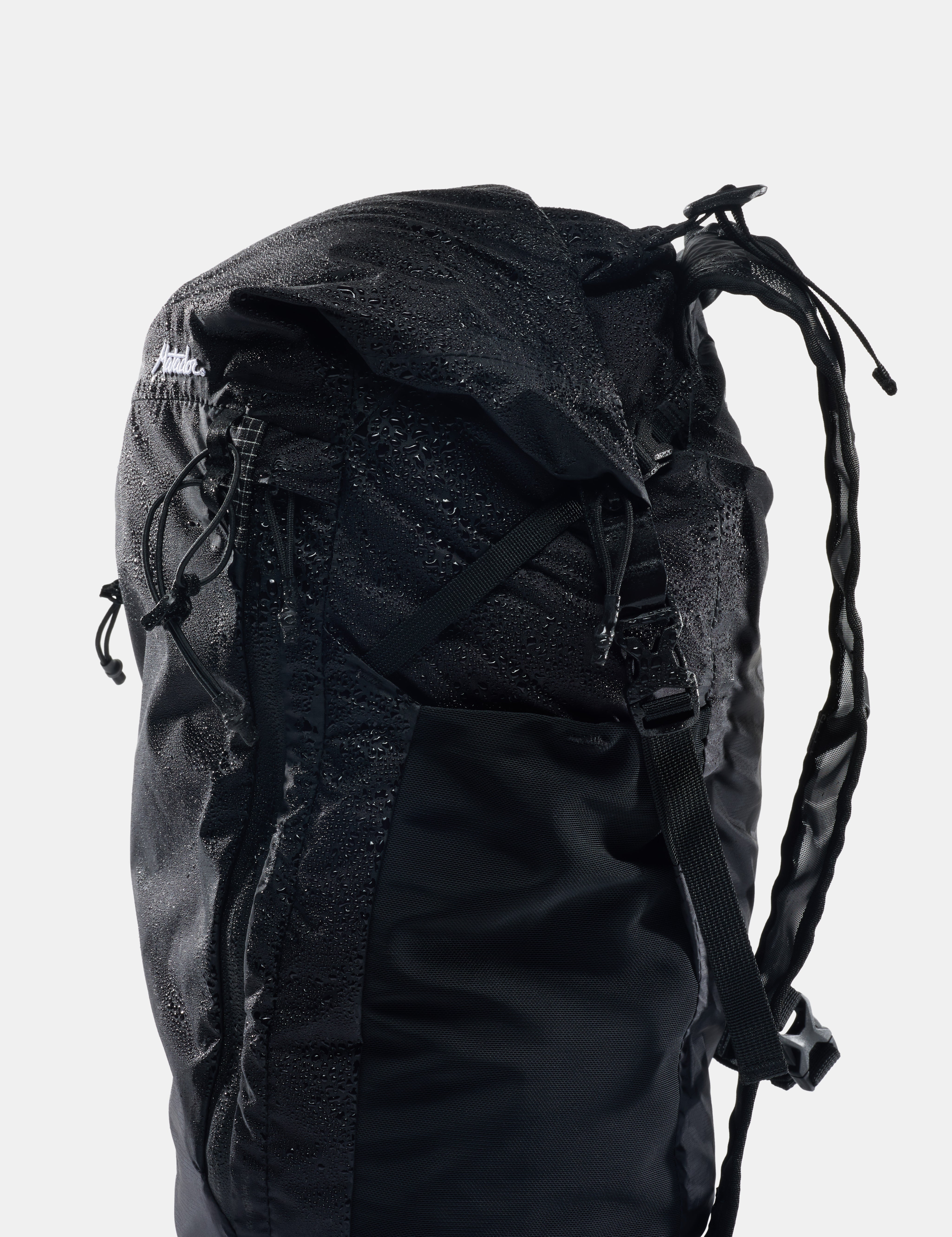 Black backpack with visible brand logo on a light gray background
