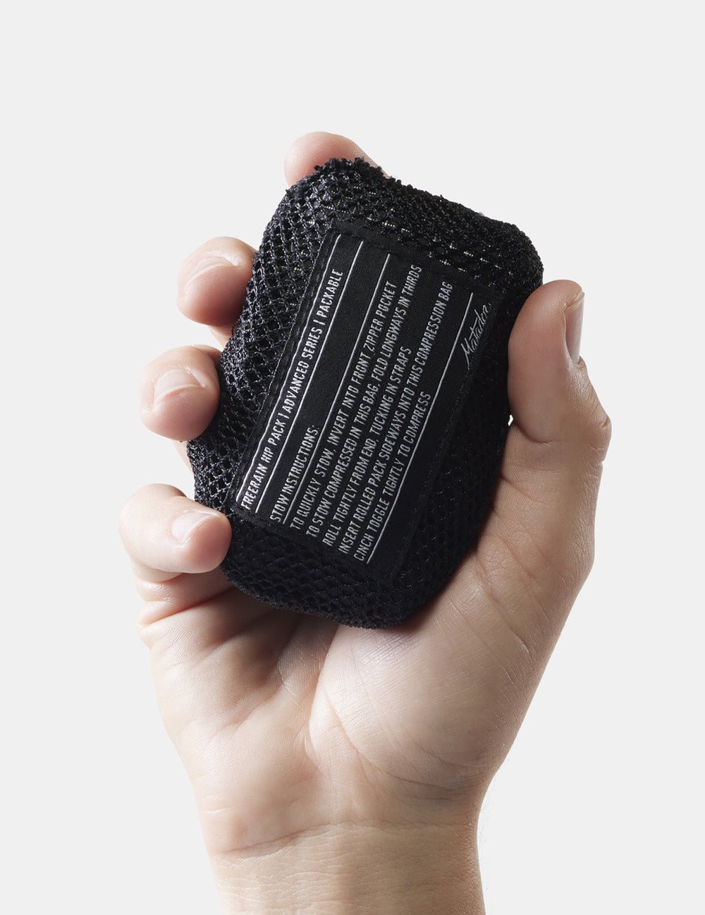 hand holding packed up hip pack on white background