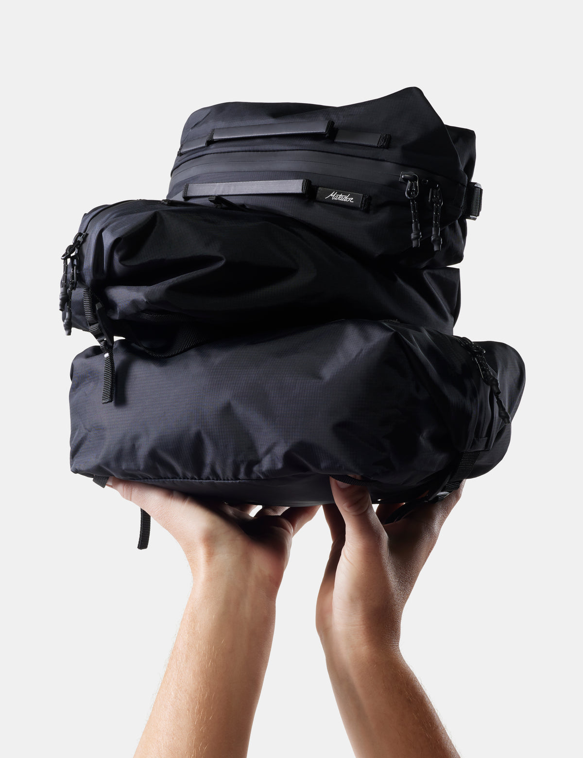 stack of black gear cubes being held up on white background
