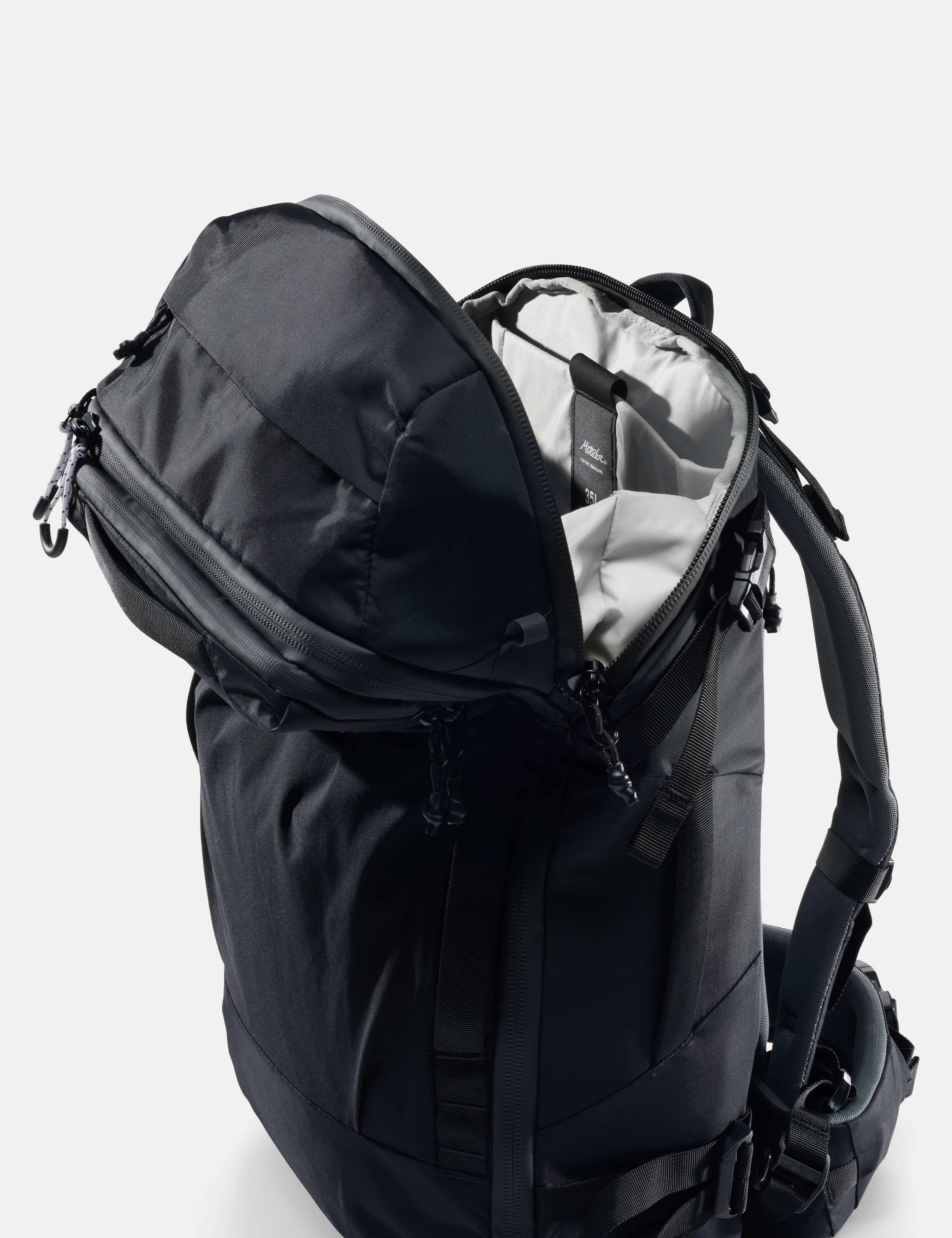 Black backpack with open front compartment on a white background
