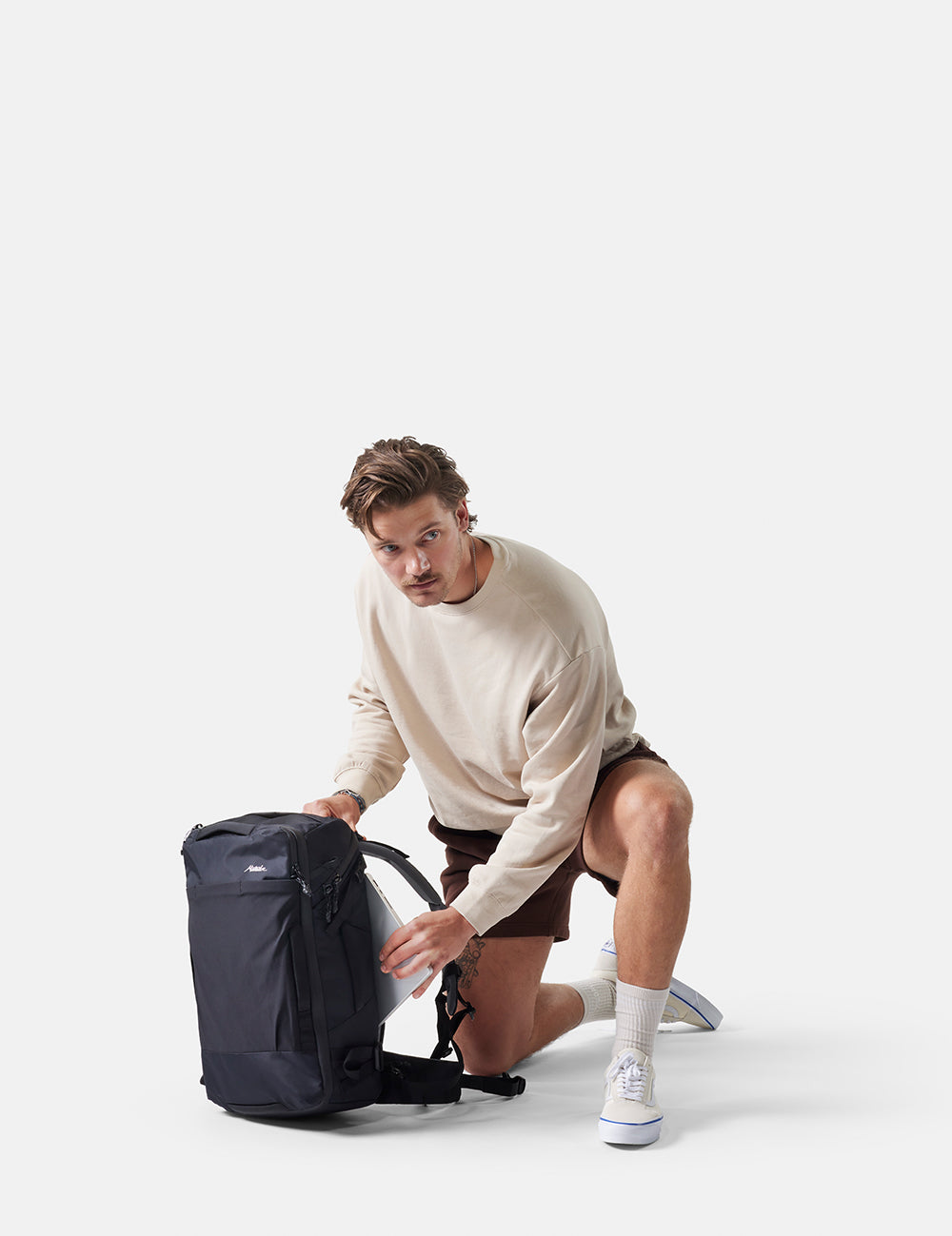Man unpacking a backpack on a white background