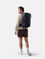 Person wearing a black backpack on a white background
