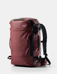 Maroon backpack with black straps on a white background