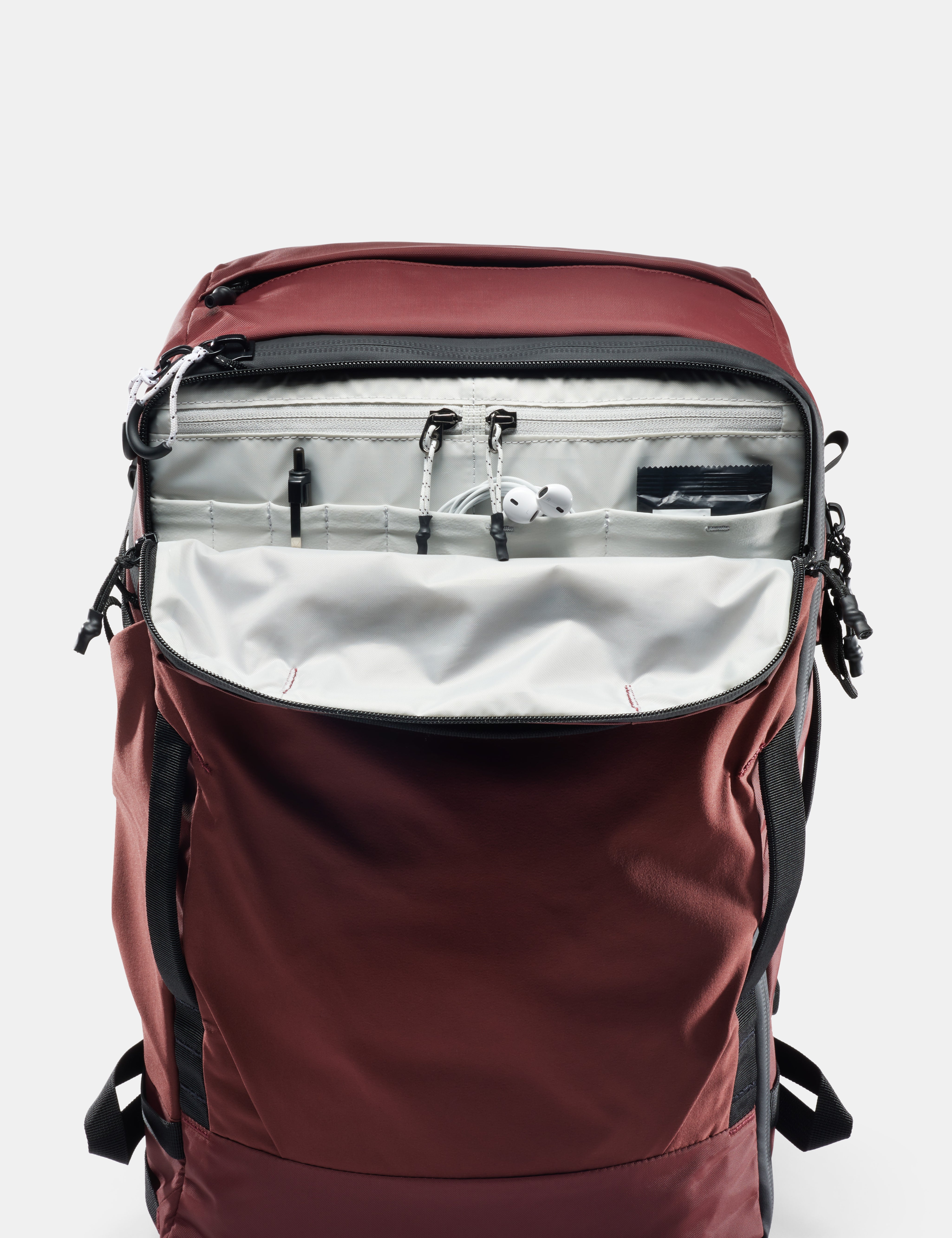 Maroon backpack with open front compartment on a light gray background