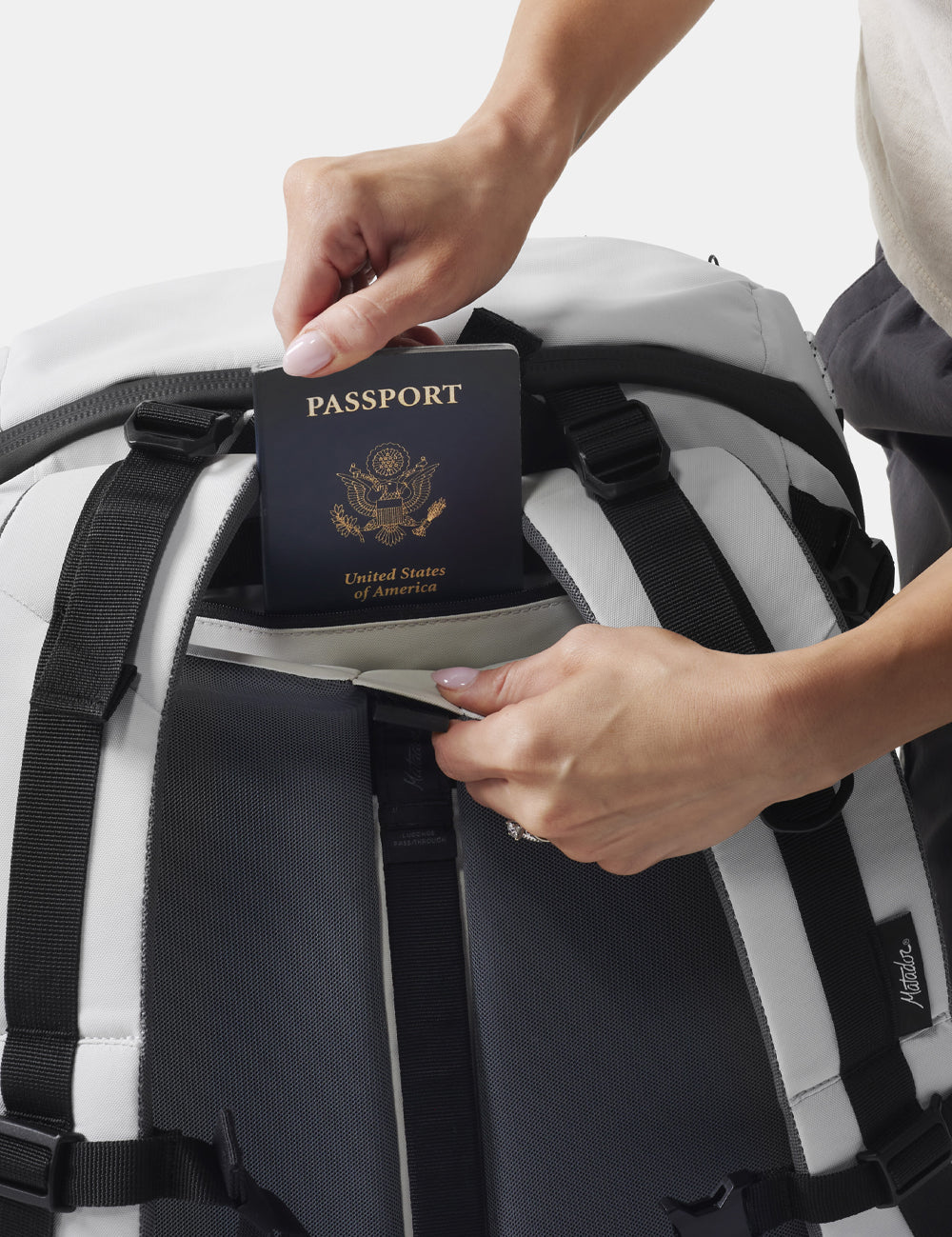 hands placing passport in hidden backpack pocket