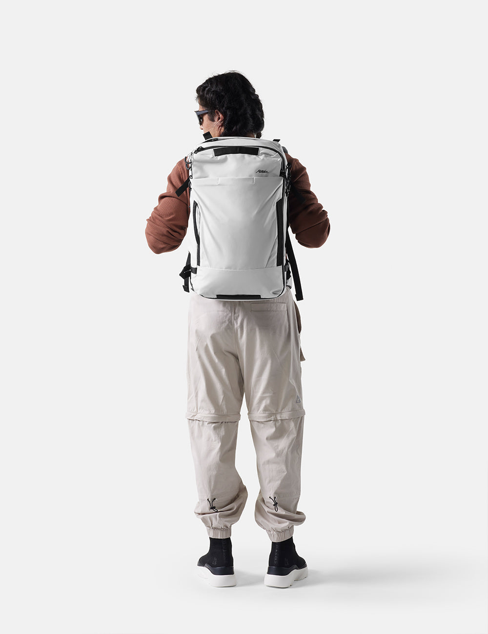 Person wearing a white backpack on a white background