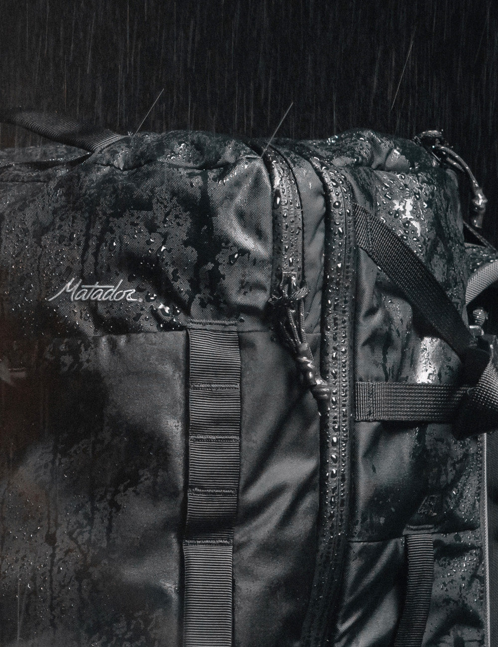 close up view of water beading off black backpack