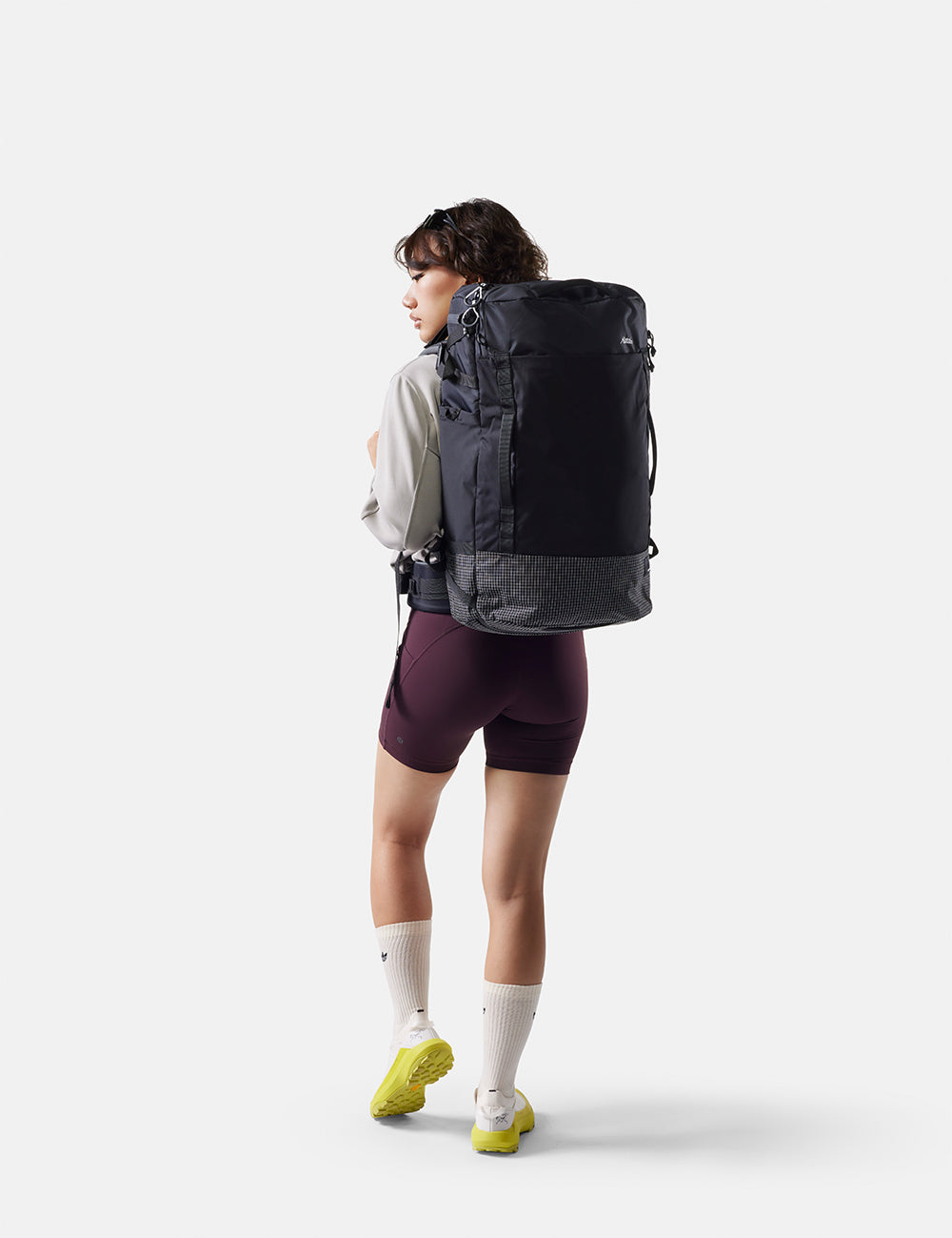 Person wearing a black backpack on a white background