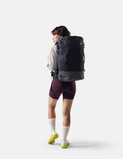 Person wearing a black backpack on a white background