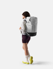 Person wearing a gray backpack on a white background