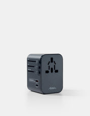 Black travel adapter on a white background