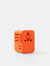 Orange travel adapter on a white background