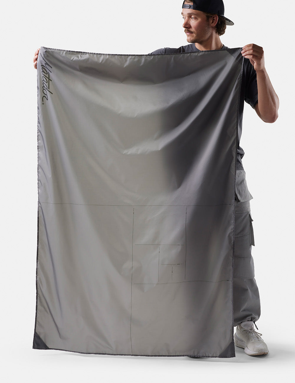 man on white background holding out pocket blanket