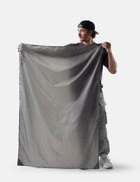 Person holding a large gray fabric against a white background