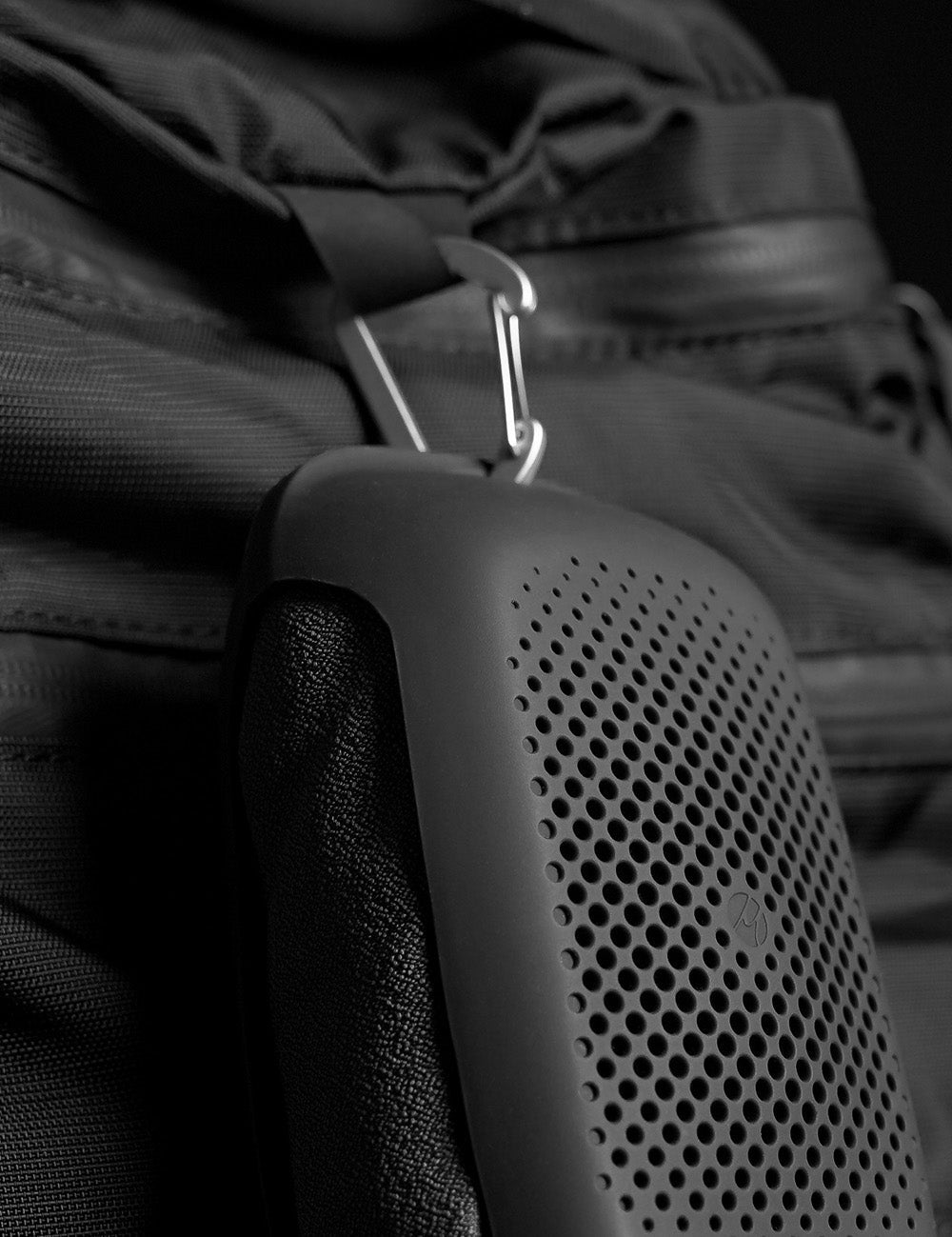 towel case hanging from black backpack from carabiner 