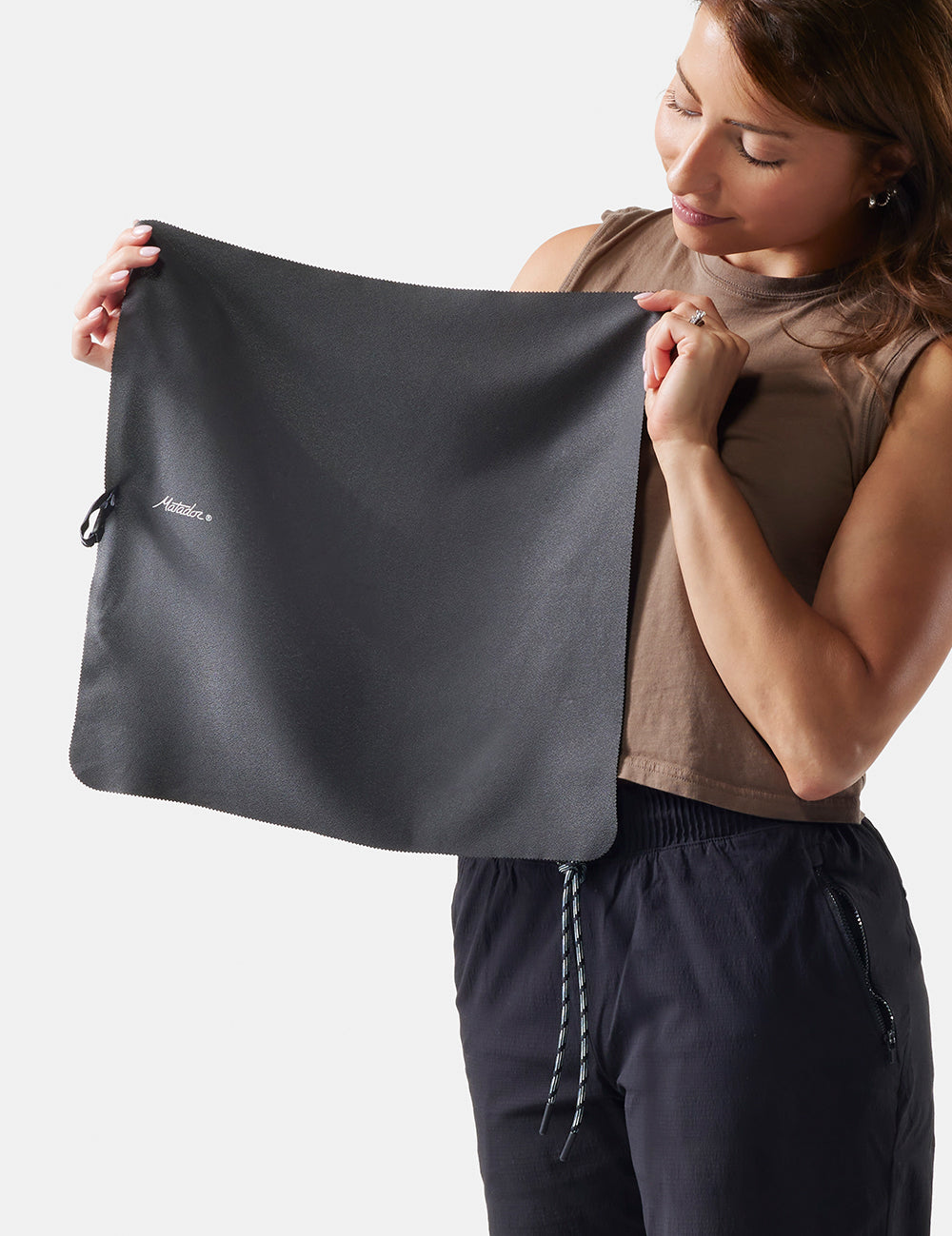 woman holding out small towel on white background