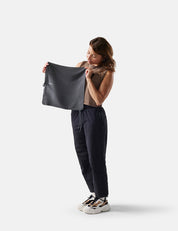 Woman holding a black towel against a white background