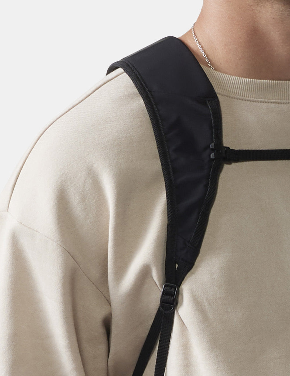 close up view of black backpack strap on a person&#39;s shoulder