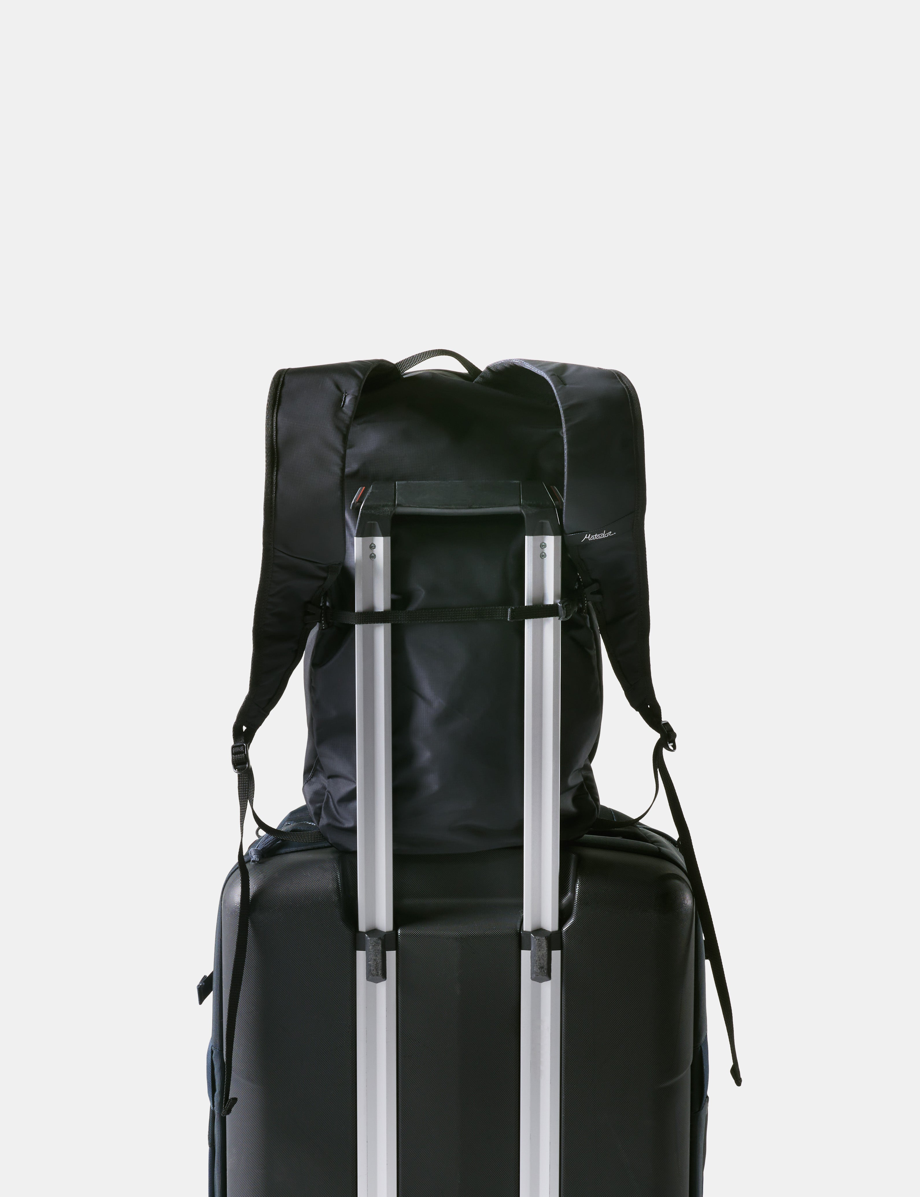 Black backpack and suitcase on a light gray background