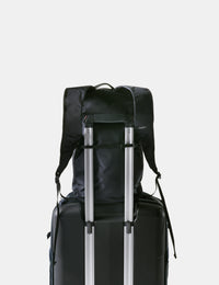 Black backpack and suitcase on a light gray background