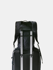 Black backpack and suitcase on a light gray background