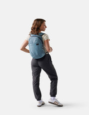 Person wearing a blue backpack on a white background