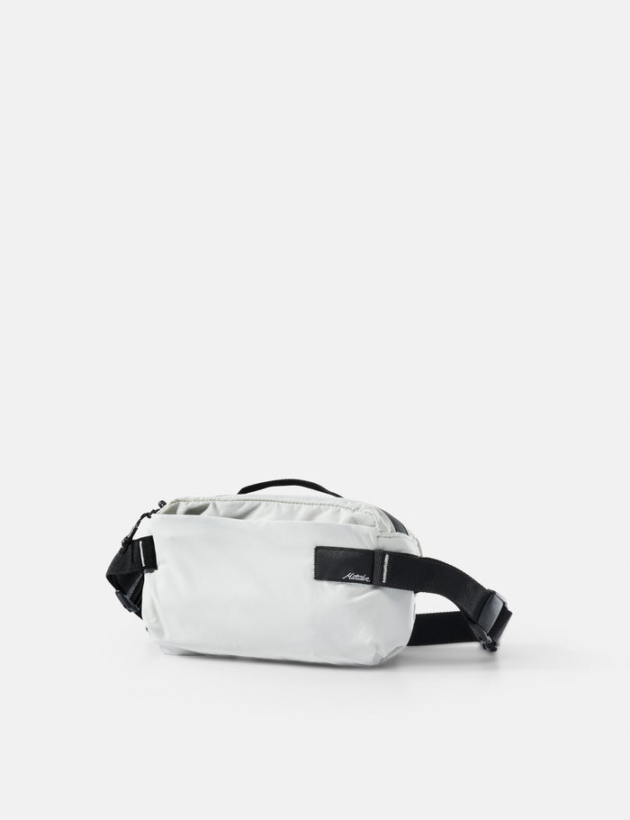 White waist bag with black strap on a light gray background