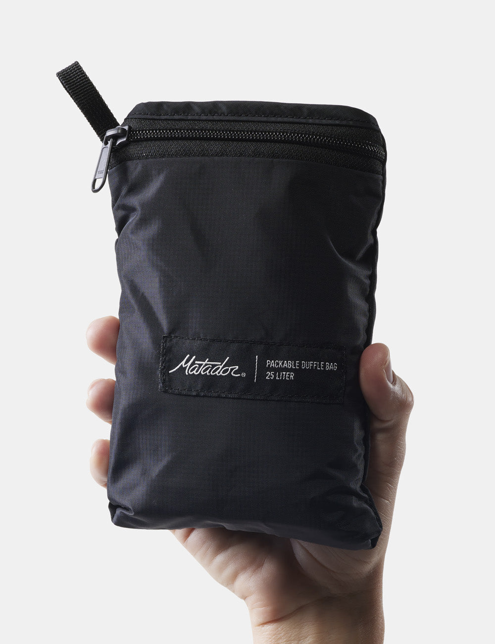 hand holding packed up duffle bag