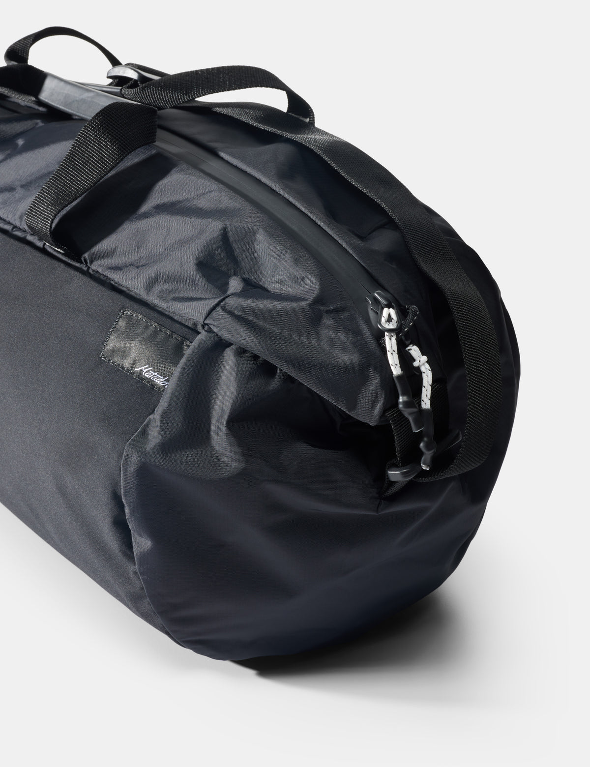 Black duffel bag with visible brand logo on a light gray background