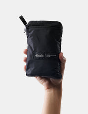 Black zippered pouch held by a hand on a white background