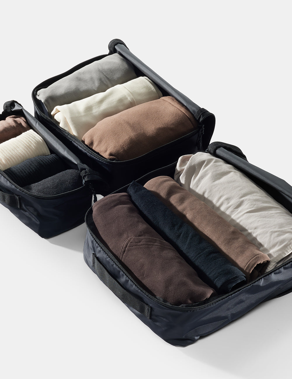 3 packing cubes open to reveal rolled clothing