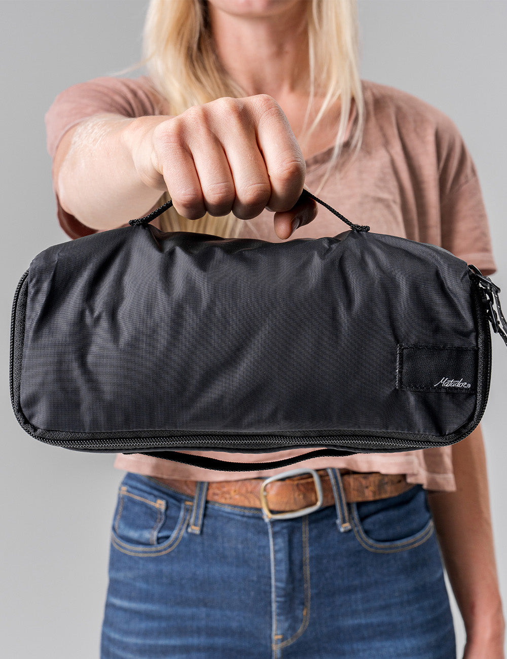 woman holding small packing cube by grab handle
