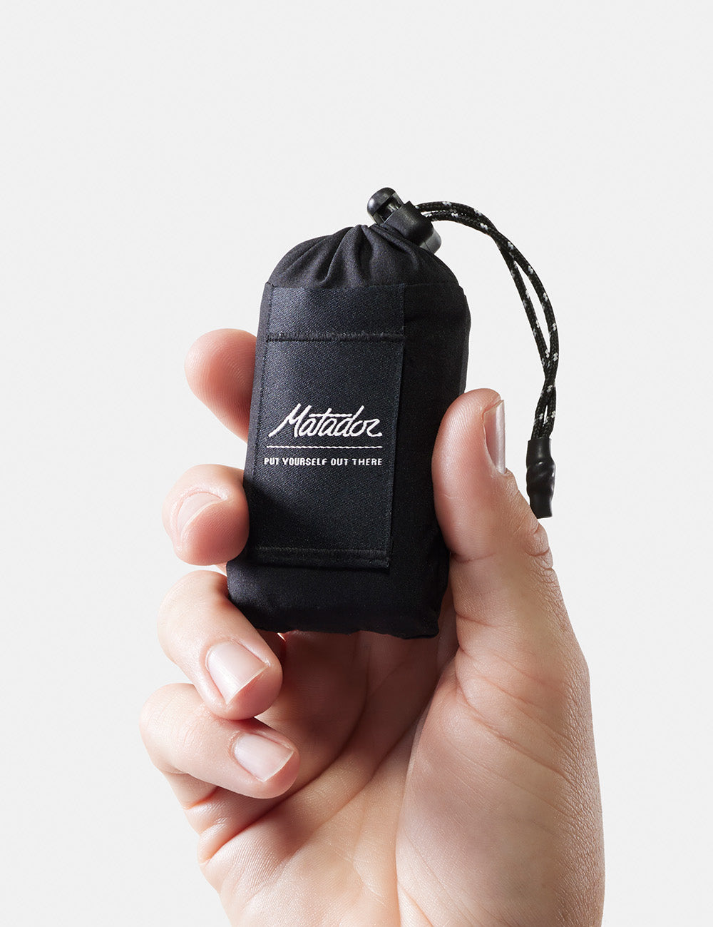 hand holding packed up pocket blanket mini