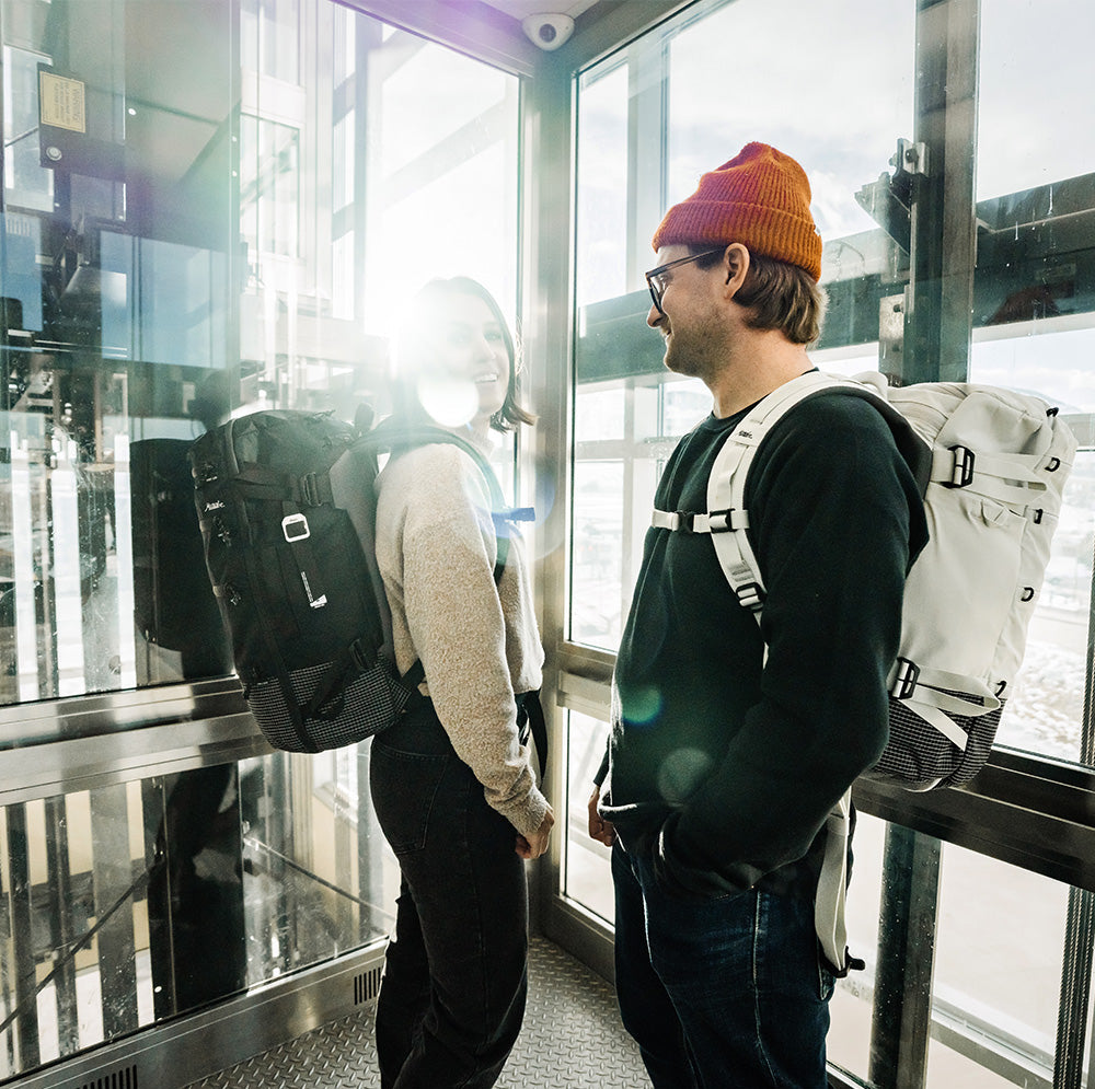 two people in airport elevator wearing black and white seg28

