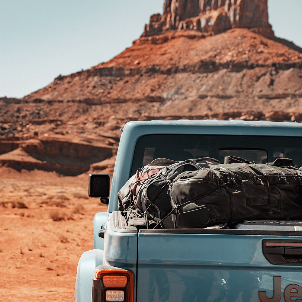 blue jeep full of gear overlooking utah landscape