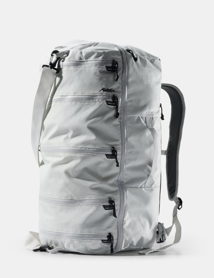 Light gray backpack with multiple zippers on a white background