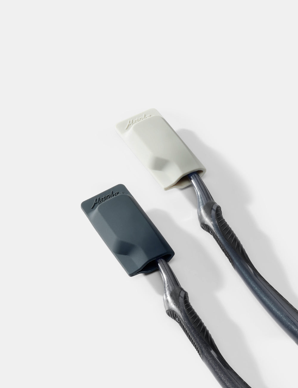 two toothbrushes and caps on a white background