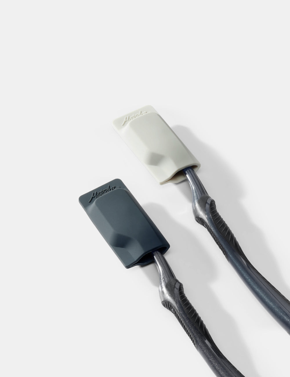 two toothbrushes and caps on a white background