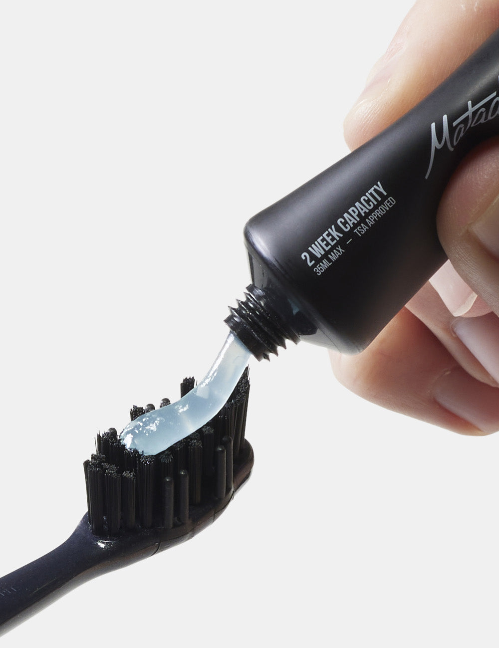 toothpaste being squeezed onto toothbrush
