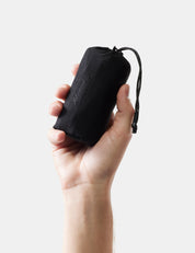 Hand holding gray towel with 'Matador' branding against a light background