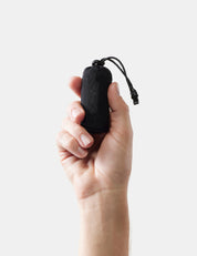 Hand holding gray pouch against a white background