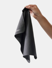 Person holding a gray towel with a brand logo on a white background