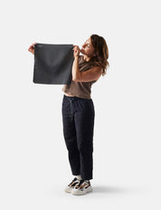 Person holding a gray towel against a white background