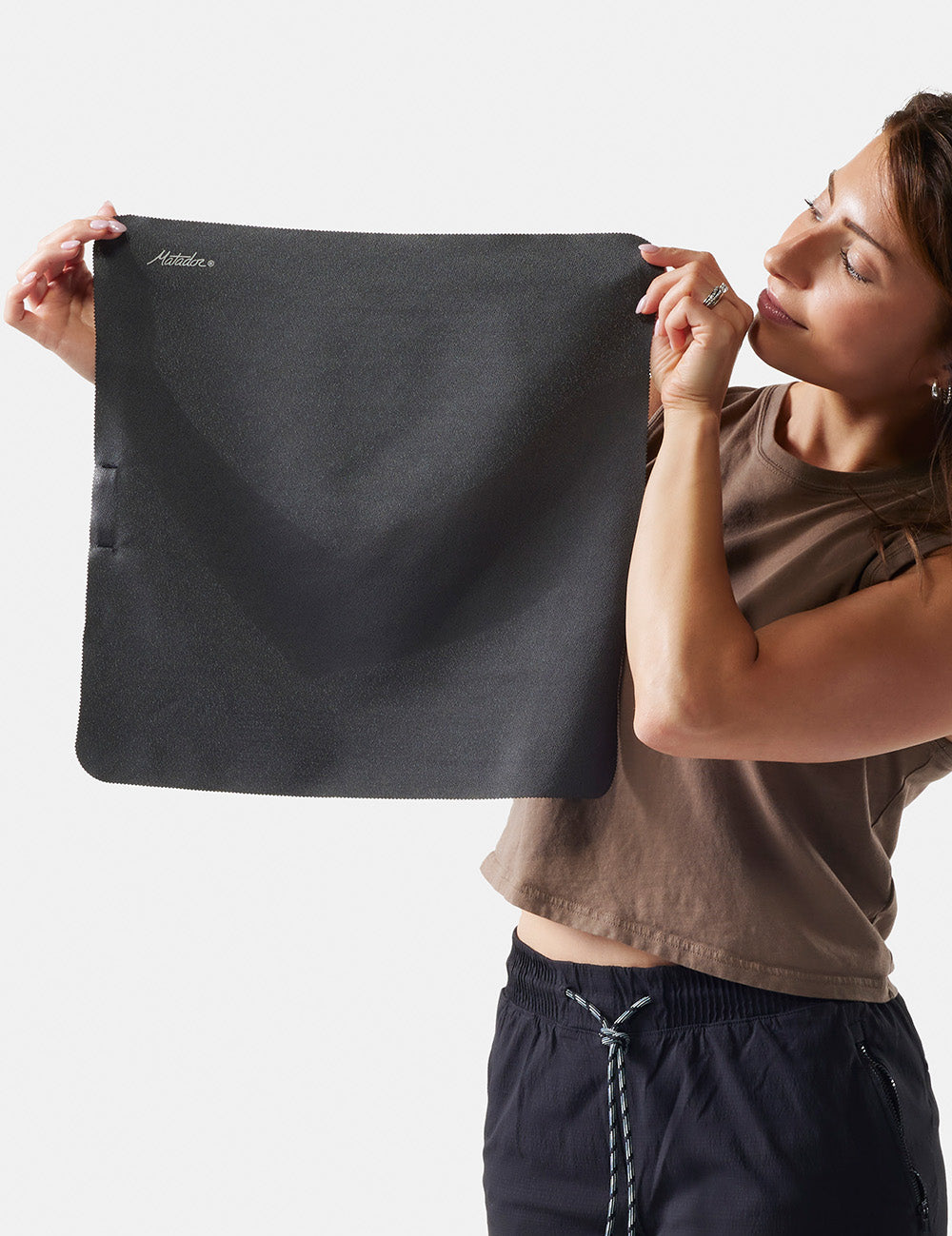 woman holding up small towel